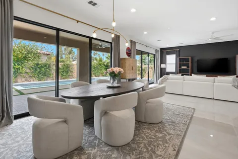 a living room with furniture a flat screen tv and a large window