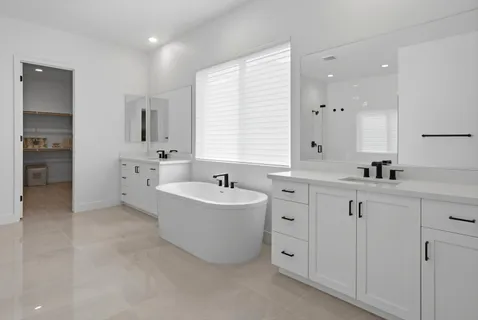 a spacious bathroom with a double vanity sink mirror and bathtub
