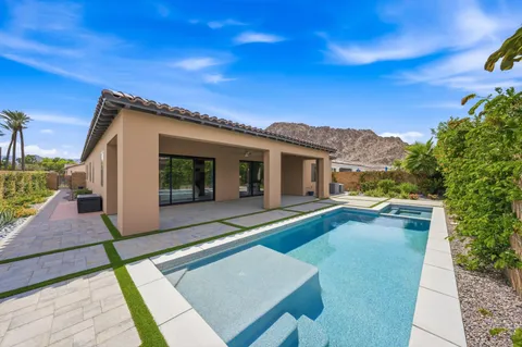 a view of a house with backyard and sitting area