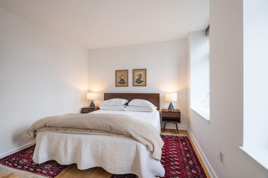 11 East 29th Street, Unit 16B Manhattan, NY 10016 - Photo 3 of 6 a bedroom with a bed and wooden floor
