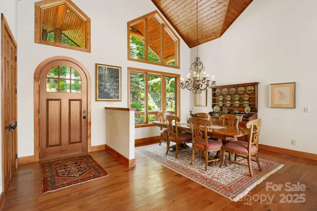 a living room with furniture a chandelier and a floor to ceiling window