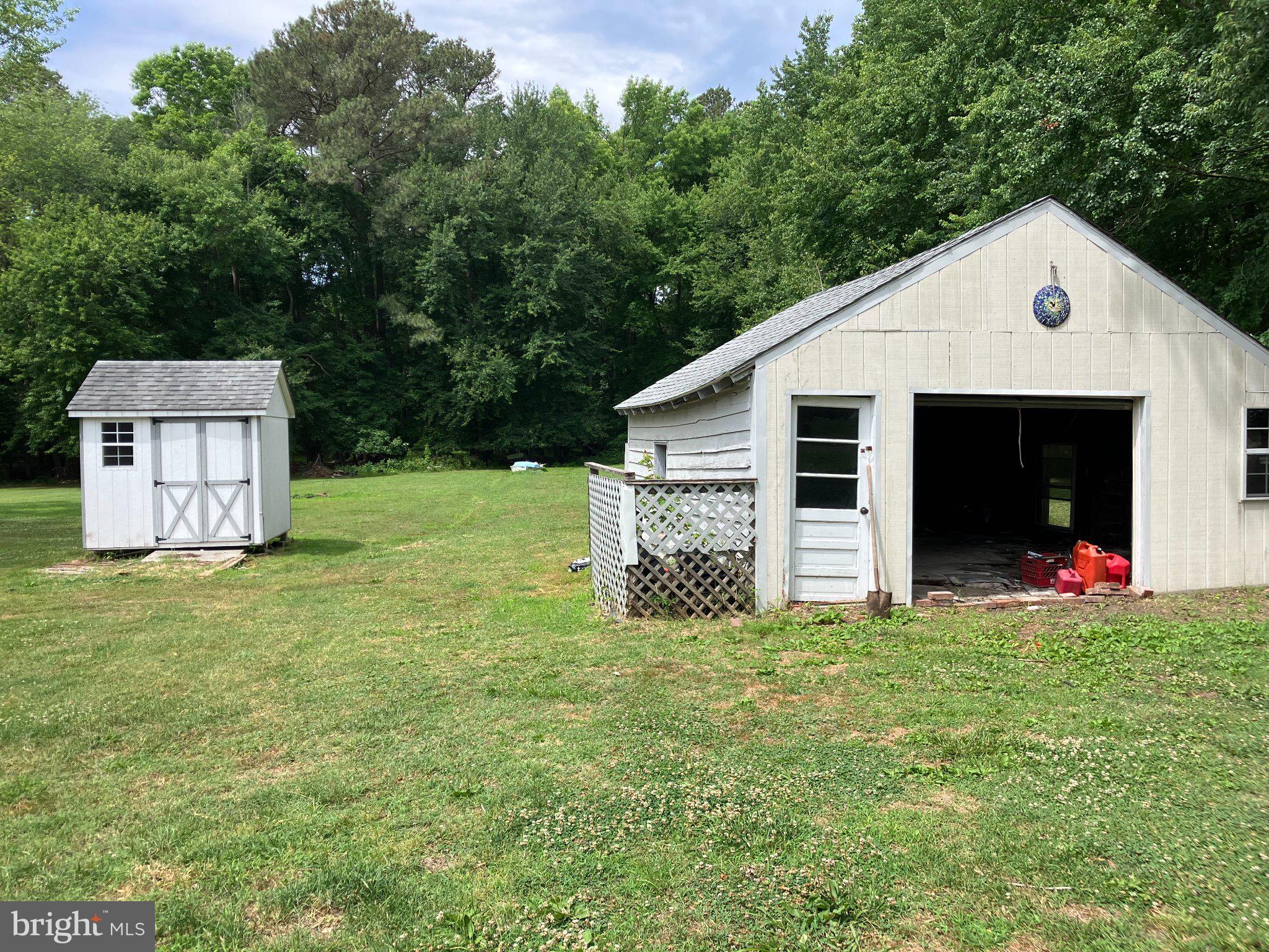 4818 Piney Neck Road Rock Hall, MD 21661 - Photo 3 of 3 Charming outbuildings in lush greenery.