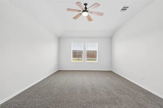 an empty room with a window and a fan