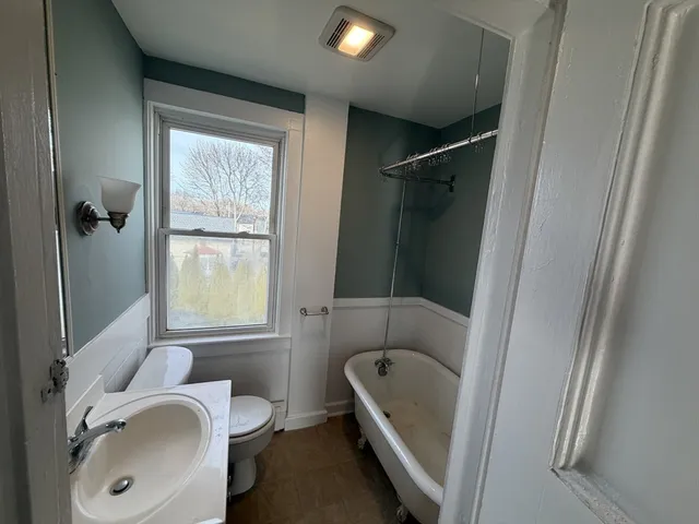 a view of an empty room with closet and a window