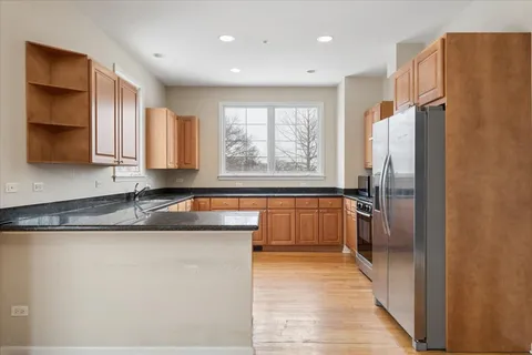 a kitchen with stainless steel appliances granite countertop a refrigerator a sink and a stove