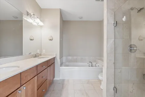 a spacious bathroom with a tub sink mirror and a shower