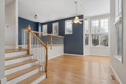 a view of an empty room with wooden floor and windows