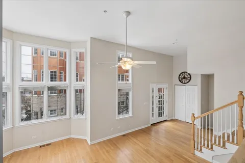 a view of empty room with wooden floor and fan