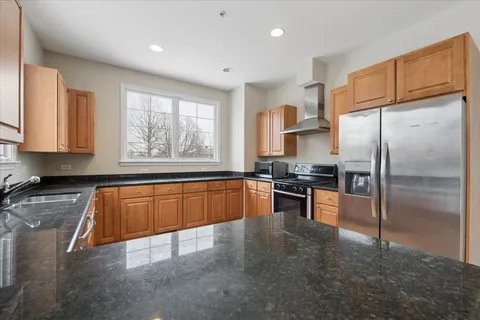 a kitchen with stainless steel appliances granite countertop a refrigerator sink and cabinets