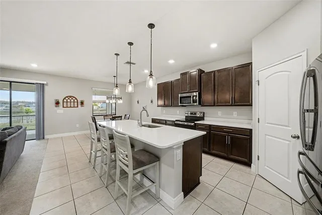 a kitchen with stainless steel appliances granite countertop a stove top oven a sink a counter top space and cabinets