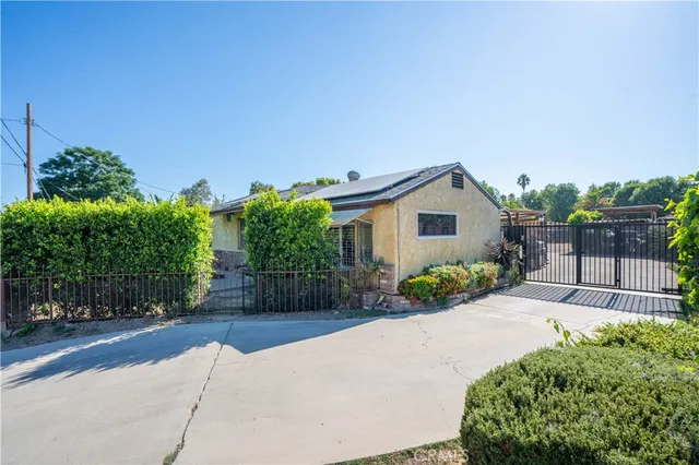 a view of a house with a yard and potted plants