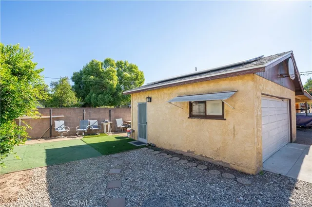 a view of a house with backyard and sitting area