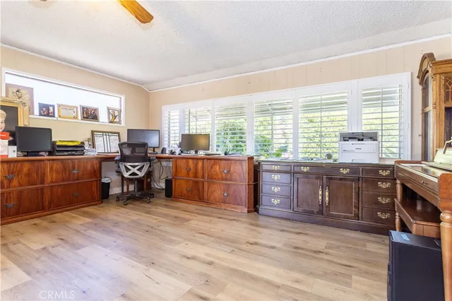 a view of a workspace with furniture and a window
