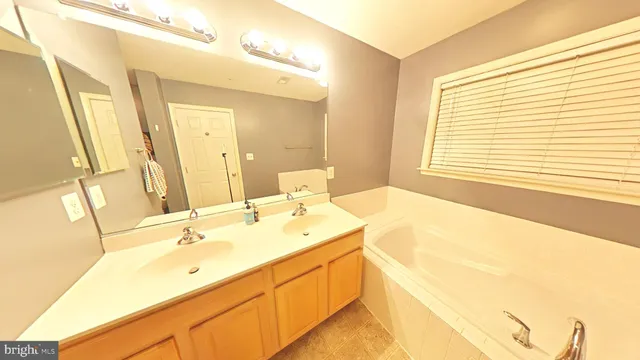 a spacious bathroom with a double vanity sink and a mirror