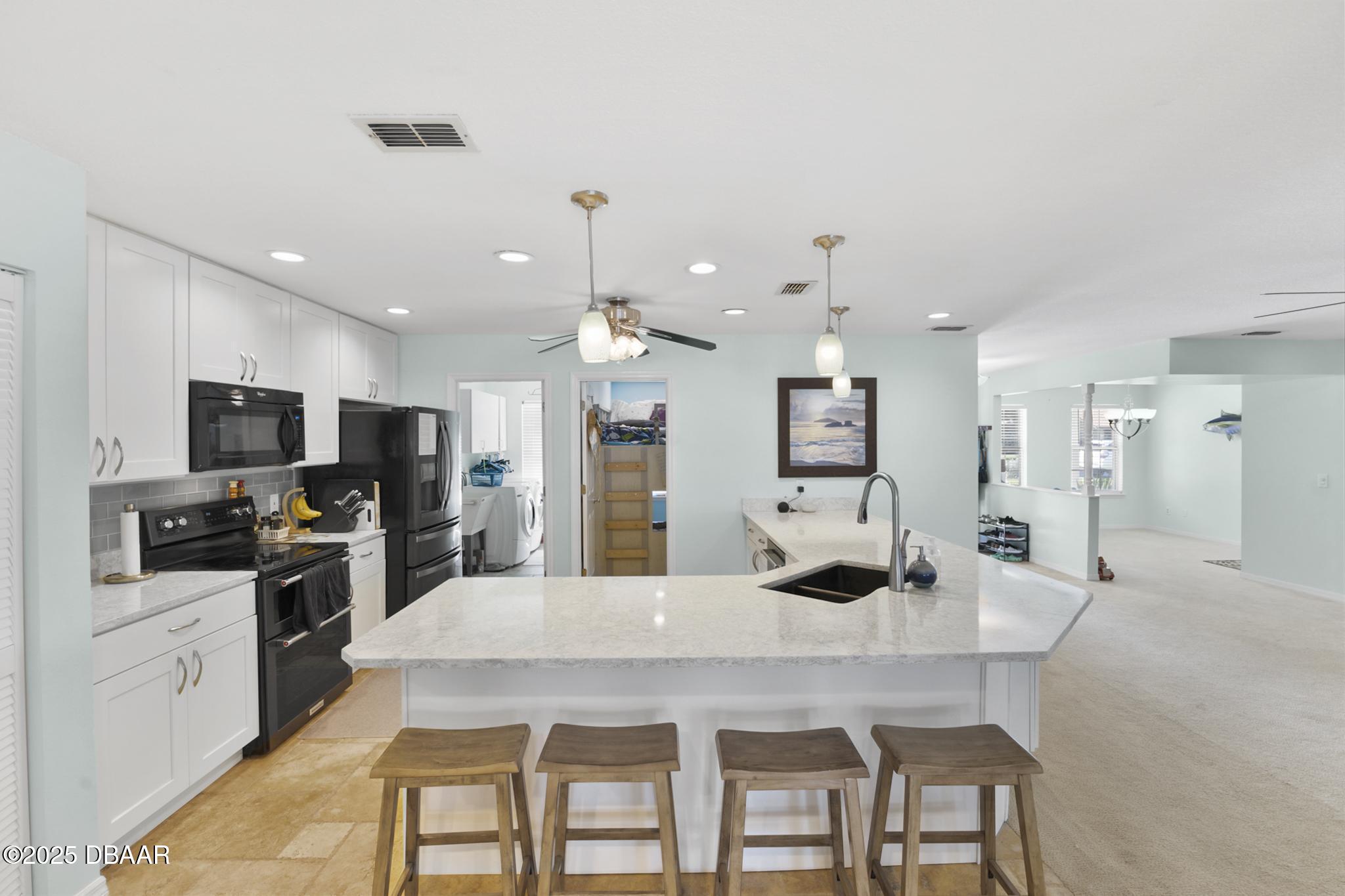 13 Fernery Trail Ormond Beach, FL 32174 - Photo 11 of 57 a kitchen with stainless steel appliances kitchen island granite countertop a sink and cabinets
