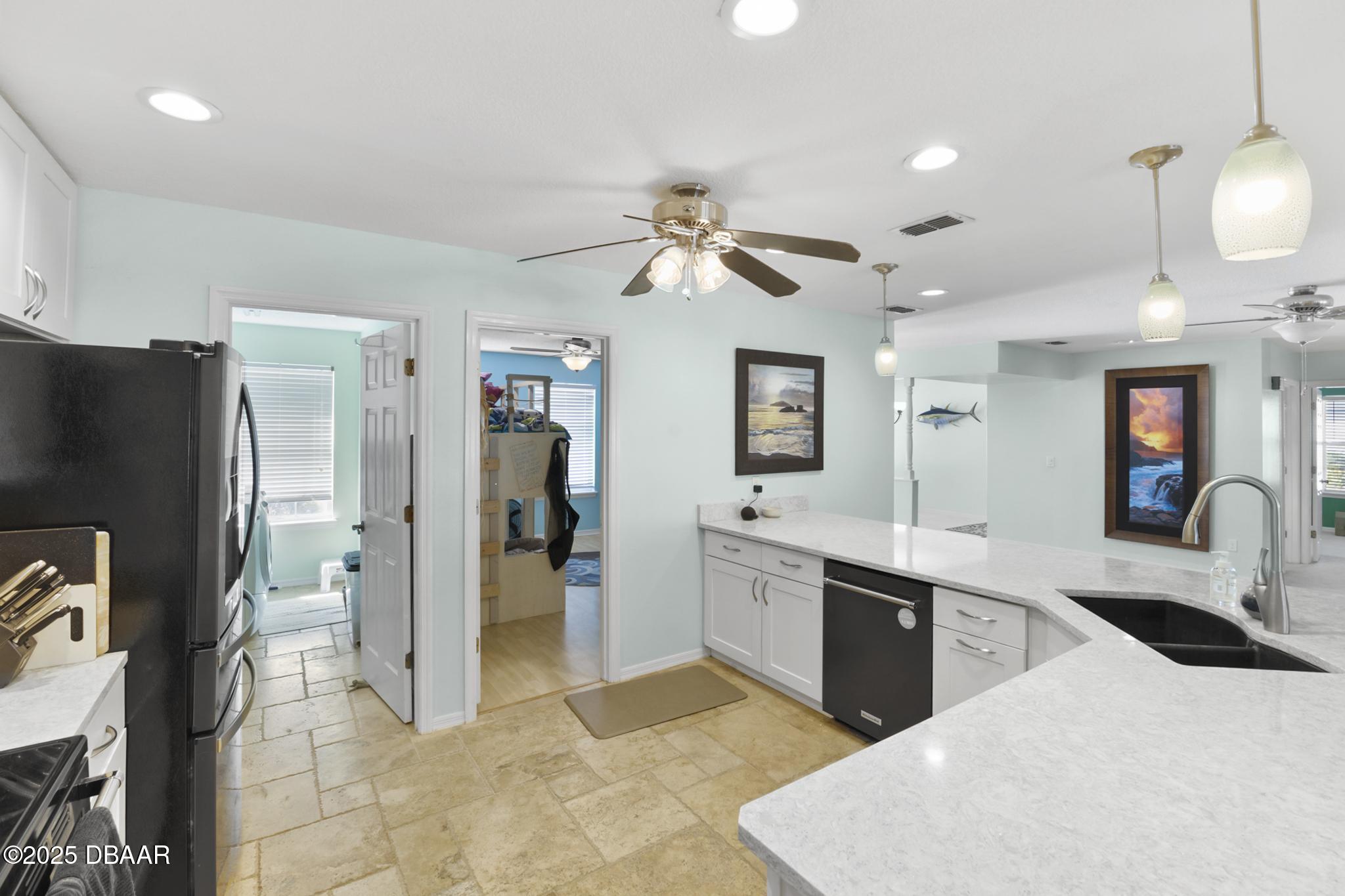 13 Fernery Trail Ormond Beach, FL 32174 - Photo 12 of 57 a large kitchen with stainless steel appliances kitchen island granite countertop a refrigerator and a sink