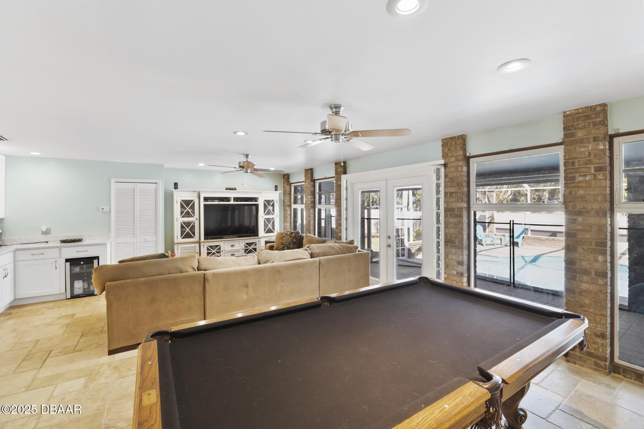 13 Fernery Trail Ormond Beach, FL 32174 - Photo 16 of 57 a large living room with stainless steel appliances kitchen island granite countertop a table chairs in it and a flat screen tv