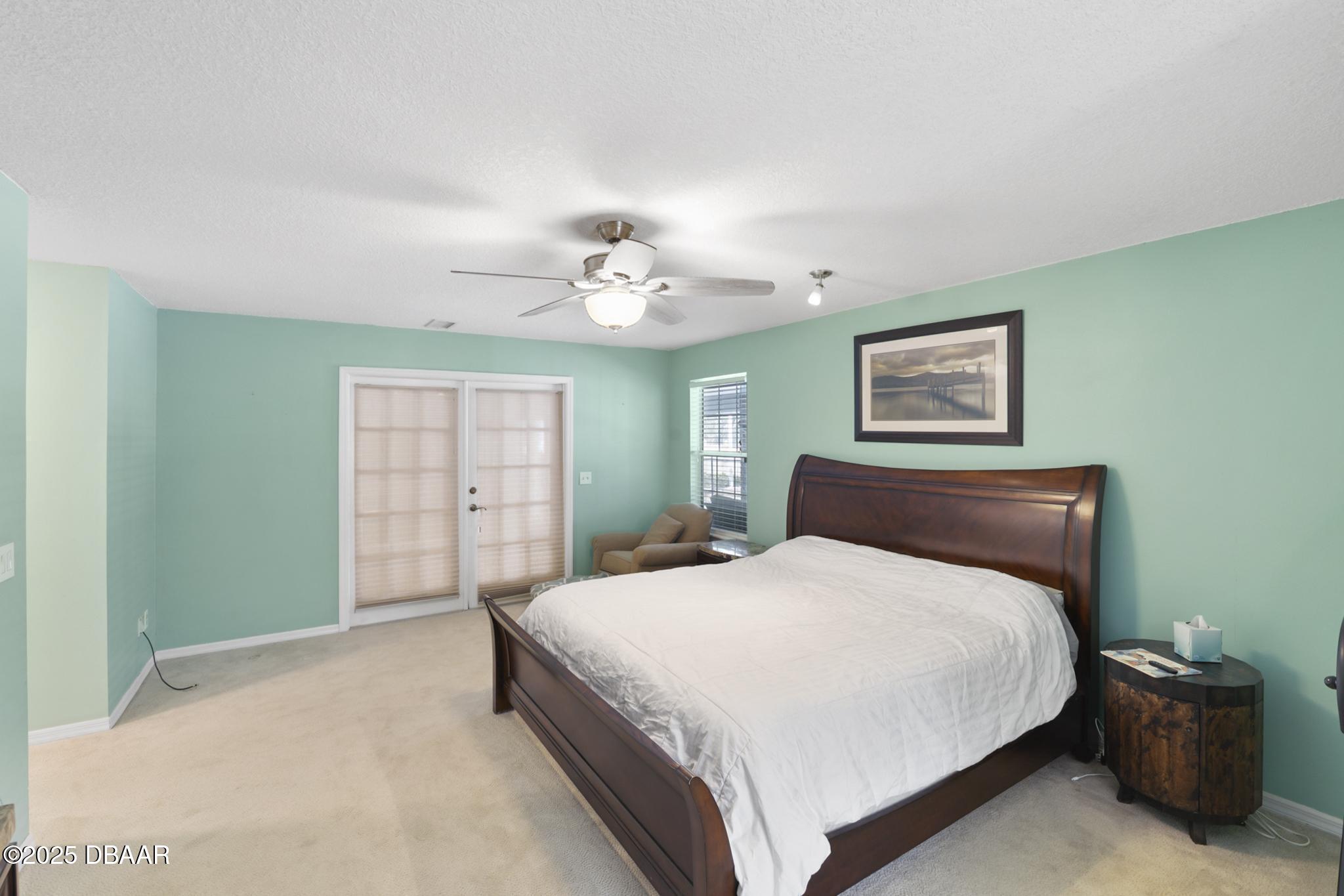 13 Fernery Trail Ormond Beach, FL 32174 - Photo 25 of 57 a bedroom with a large bed and a chandelier