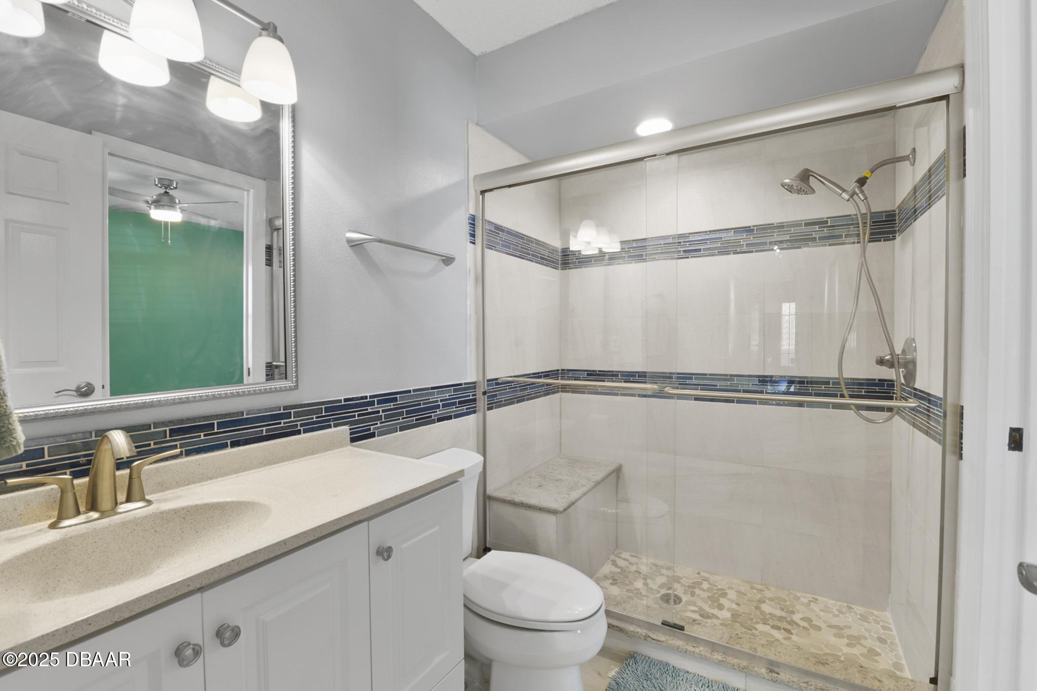 13 Fernery Trail Ormond Beach, FL 32174 - Photo 33 of 57 a bathroom with a sink a mirror a toilet and shower