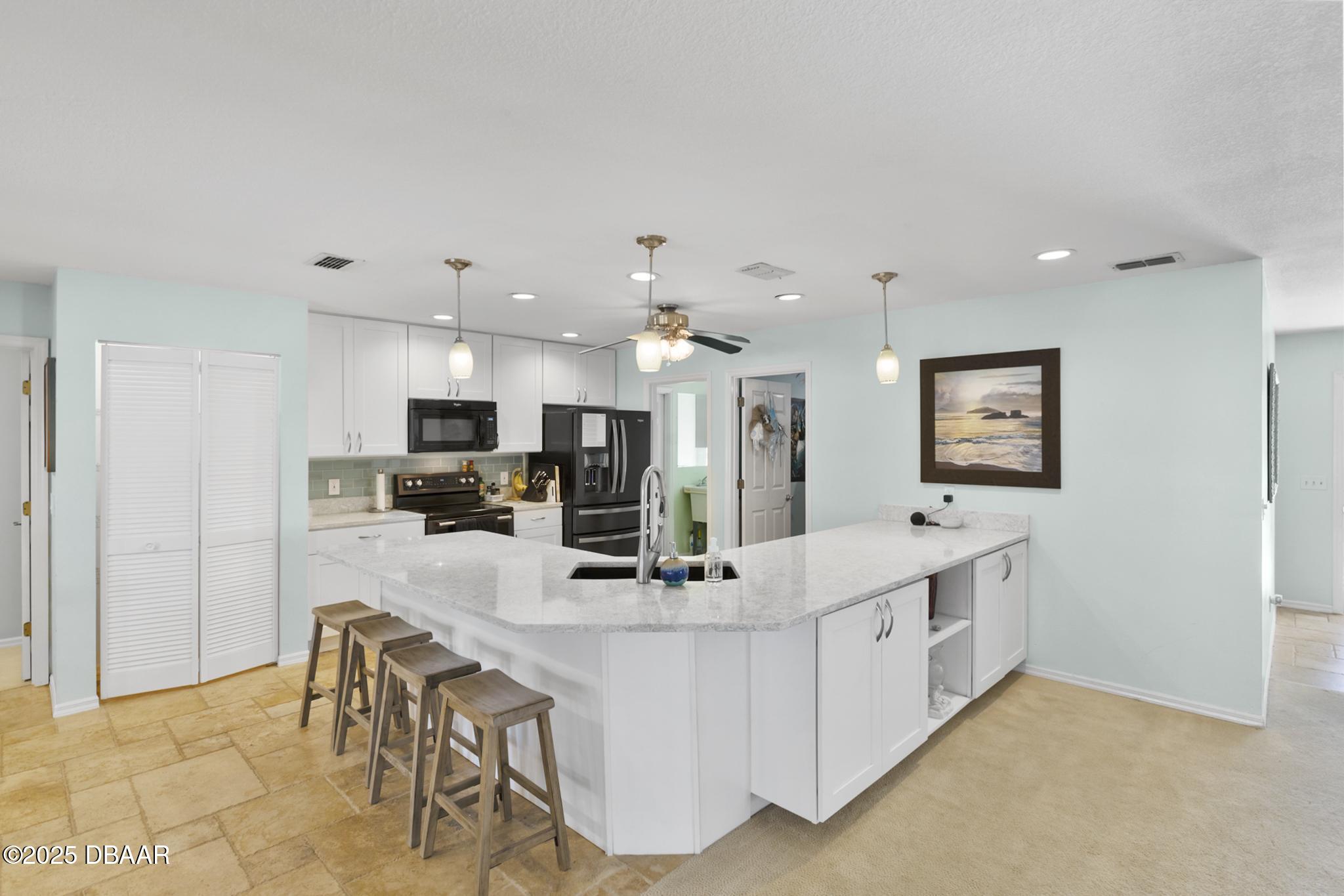 13 Fernery Trail Ormond Beach, FL 32174 - Photo 9 of 57 a view of kitchen with kitchen island stainless steel appliances sink refrigerator and dining table