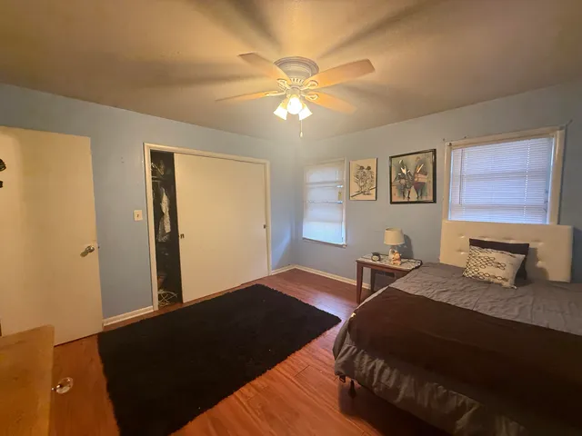 a bedroom with a bed and wooden floor