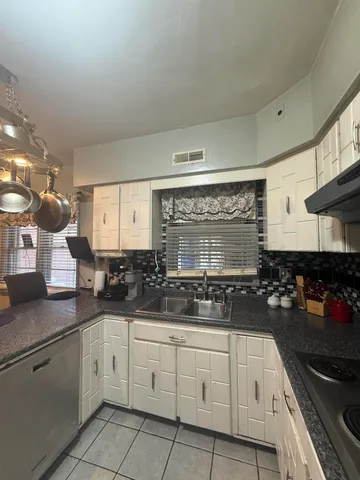 a kitchen with white cabinets and appliances