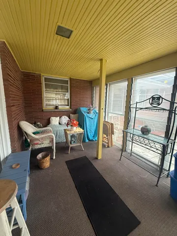 a view of a livingroom with furniture and floor to ceiling window