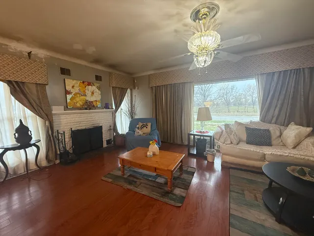 a living room with furniture a fireplace and a chandelier