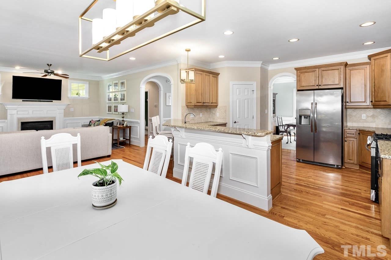 8333 Wheatstone Lane Raleigh, NC 27613 - Photo 12 of 34 a kitchen with kitchen island a sink a counter top space a refrigerator and a view of living room
