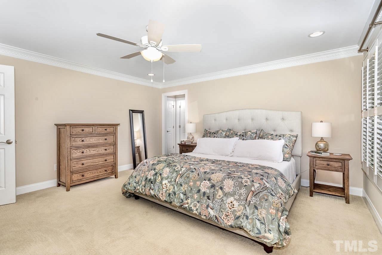8333 Wheatstone Lane Raleigh, NC 27613 - Photo 15 of 34 a bedroom with a bed a dresser and a chandelier