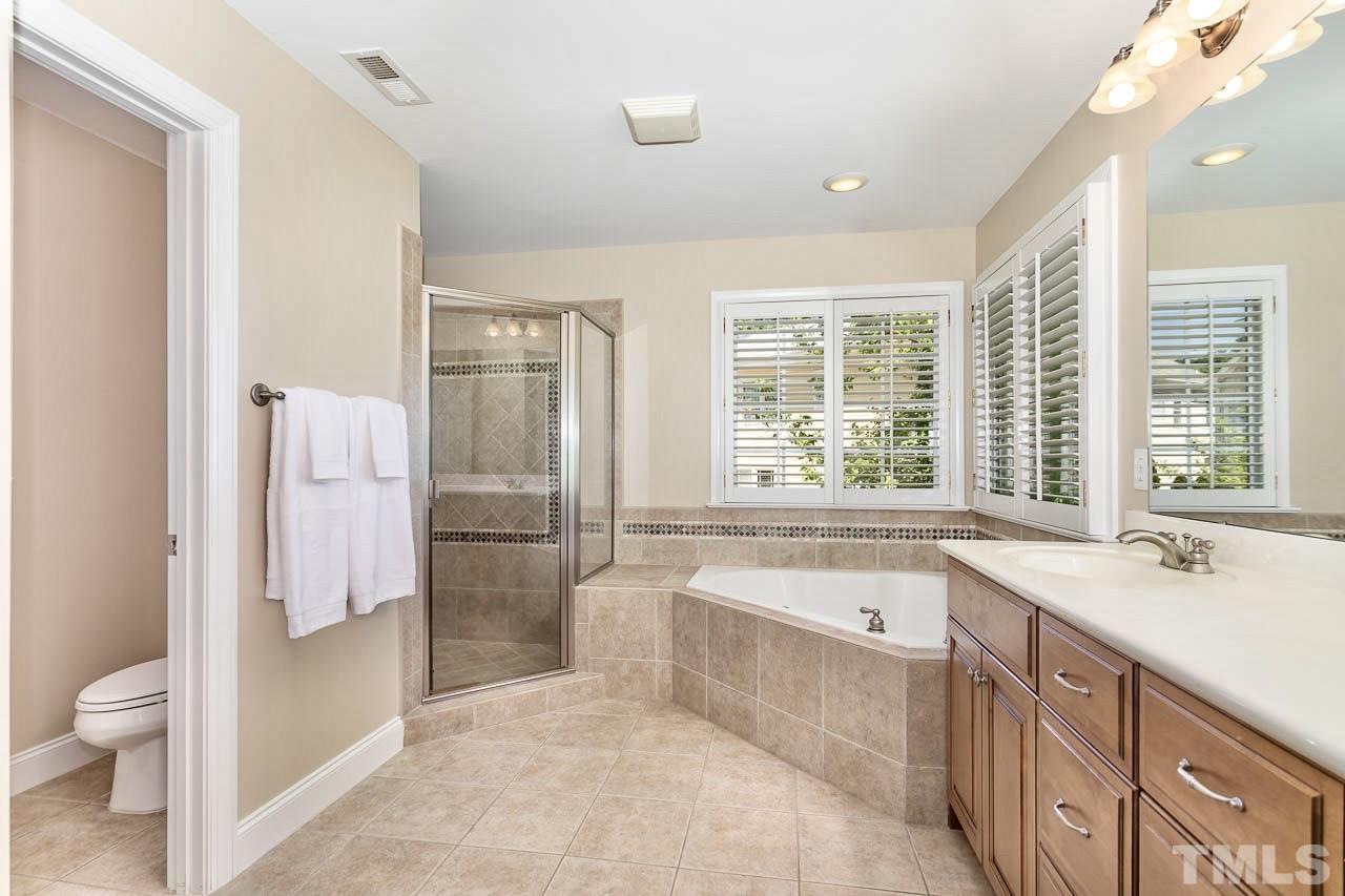 8333 Wheatstone Lane Raleigh, NC 27613 - Photo 16 of 34 a spacious bathroom with a tub sink toilet and a shower