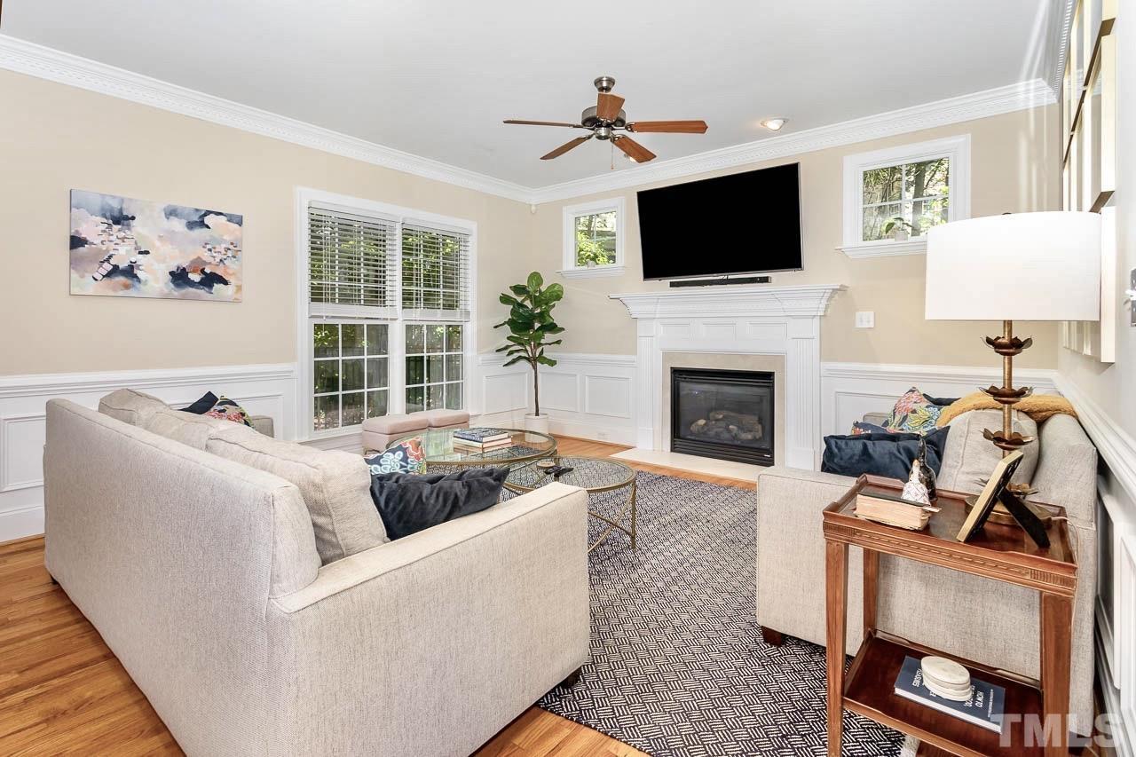 8333 Wheatstone Lane Raleigh, NC 27613 - Photo 8 of 34 a living room with furniture a fireplace and a flat screen tv