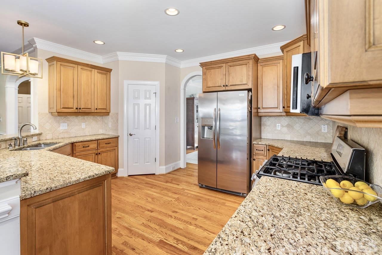 8333 Wheatstone Lane Raleigh, NC 27613 - Photo 10 of 34 a kitchen with stainless steel appliances granite countertop a refrigerator and a stove top oven