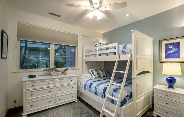 a bedroom with a bed and large windows