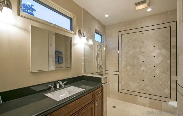 a bathroom with a shower sink and mirror