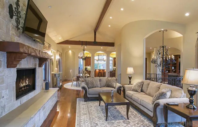a living room with furniture a fireplace and a flat screen tv