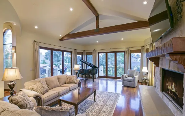a living room with furniture fireplace and large windows