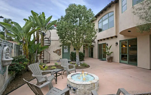 a view of a patio with table and chairs potted plants and large tree