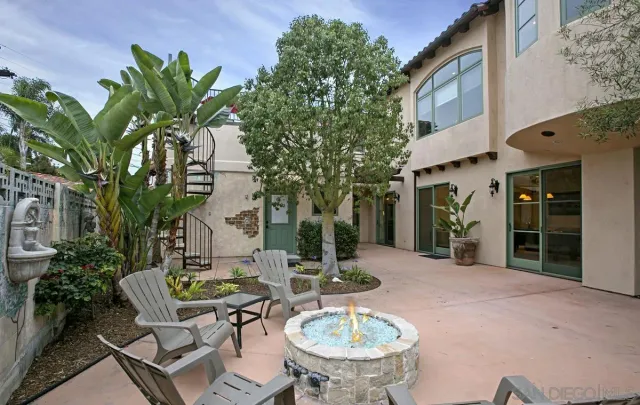 a view of a patio with table and chairs potted plants and large tree