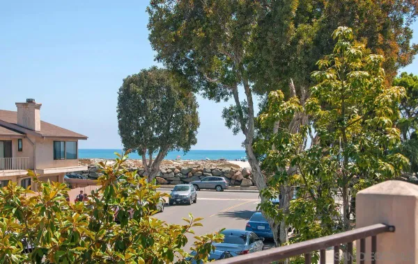 a front view of a house with a garden and trees