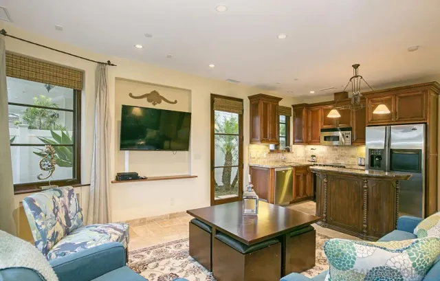 a living room with stainless steel appliances kitchen island granite countertop a couch and a view of living room
