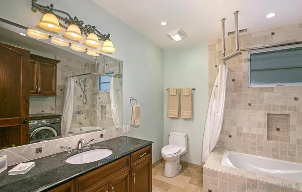 a bathroom with a granite countertop sink toilet and shower