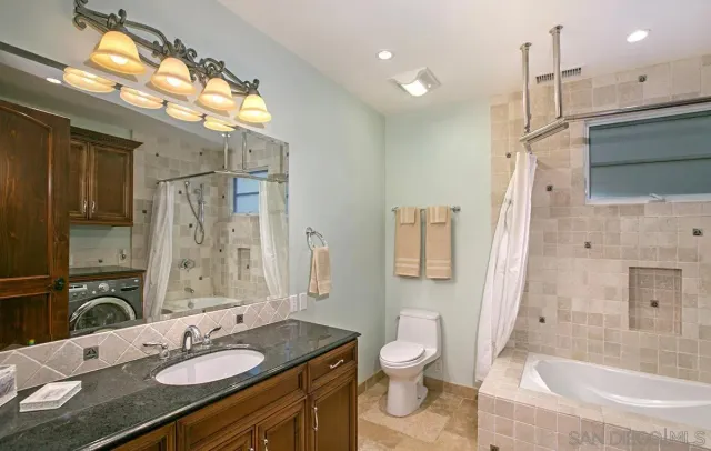 a bathroom with a granite countertop sink toilet and shower