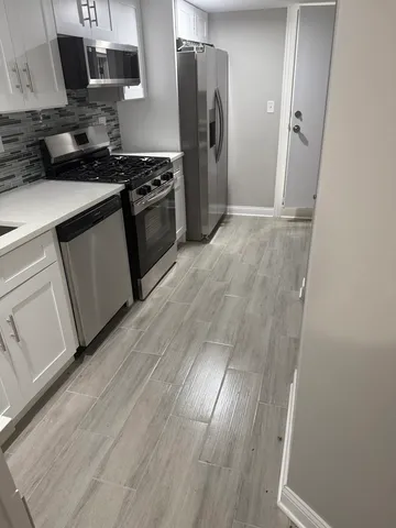 a kitchen with stainless steel appliances granite countertop a refrigerator and a stove