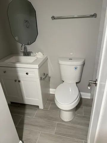a white toilet sitting next to a bathroom sink