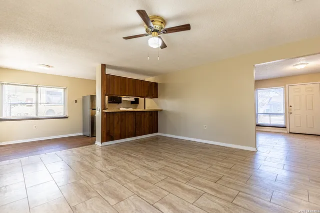 a view of an empty room with window and wooden floor