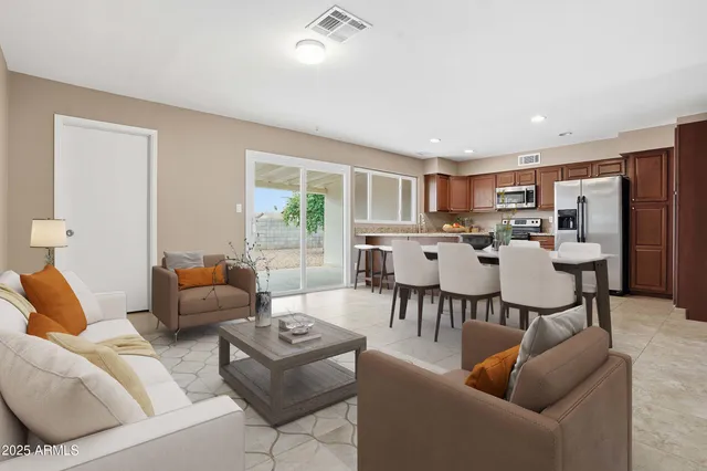 a living room with furniture and a dining table with kitchen view