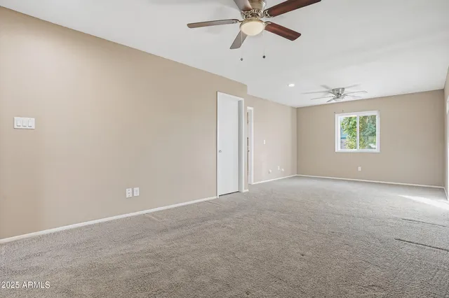 an empty room with windows and fan