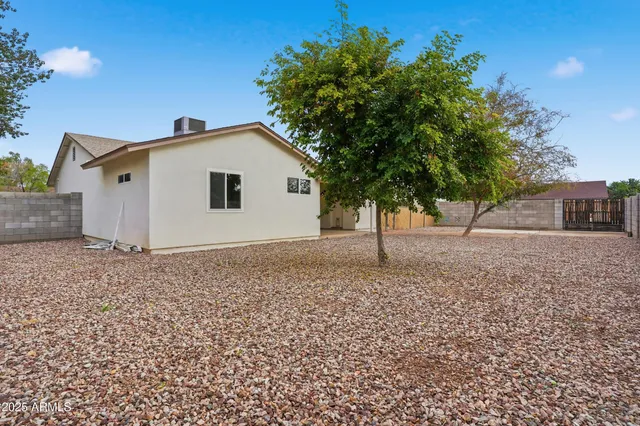 a view of house with a yard and a large tree