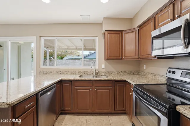 a kitchen with stainless steel appliances granite countertop a sink and a stove